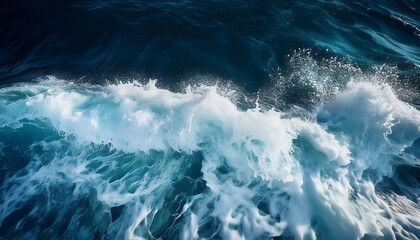 a close up view of foamy white ocean waves crashing against a dark blue background