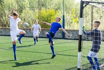Young football players fighting for ball in goalmouth zone