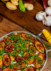 Comida brasileira na panela com arroz, carne, banana frita e temperos