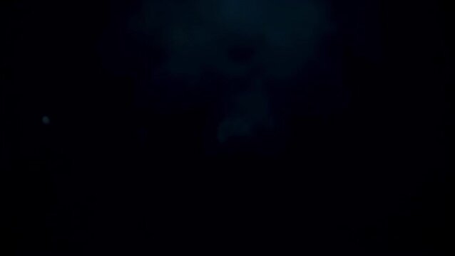 Dark abstract background with subtle light particles floating within a cloudy texture