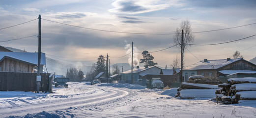Obraz premium A beautiful Winter Village Scene showcasing a SnowCovered Street and lovely Homes nearby Classic view of Russia in Winter. Russian village in Siberia, Russia, Courtyard and buildings, Narva village