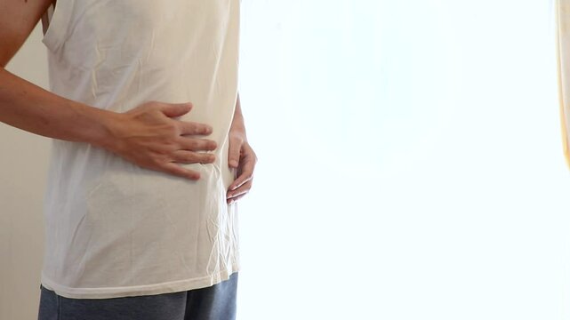 手でお腹をさする男性