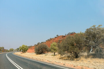 Bend in the road near Stuarts Well in the Northern Territory of Australia, showing dry outback landcape and flora.