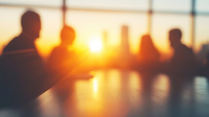 Group of professionals engaged in discussion during a business meeting, with a vibrant city skyline illuminated by sunset