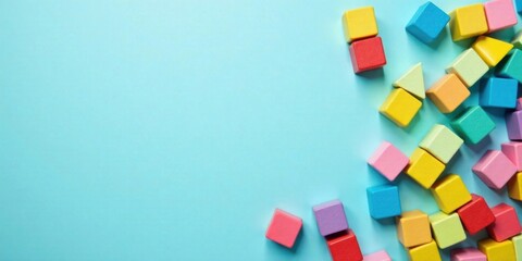 Brightly Colored Wooden Blocks Scattered on a Light Blue Background, Ideal for Educational or Playful Designs