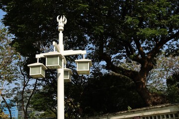 Vintage four head lamp post streetlight, large tree background