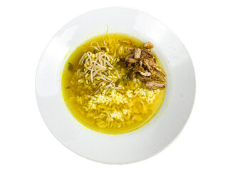 Soto ayam or chicken soup with rice, topped with bean sprouts on a white plate. Indonesian food with savory yellow sauce from turmeric