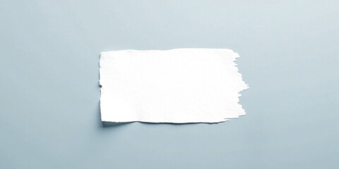 A torn piece of white paper on a light blue background, ideal for adding your text or message.