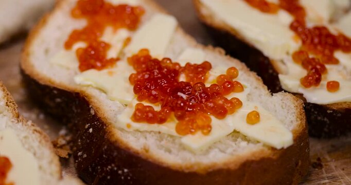 a loaf of wheat flour with butter and red salmon caviar, the use of white bread for cooking with the use of butter and red caviar