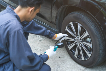 Auto mechanic man checking tire measure air pressure, measurement with gauge for car tyre, mechanic...