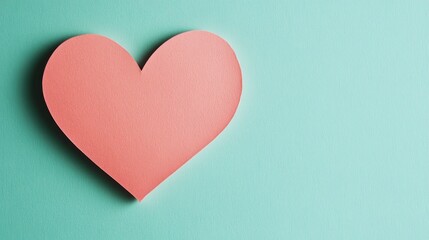 Fototapeta premium A pink paper heart on a light blue background, symbolizing love and affection.