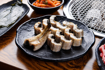 Eel on a black plate grilled over charcoal