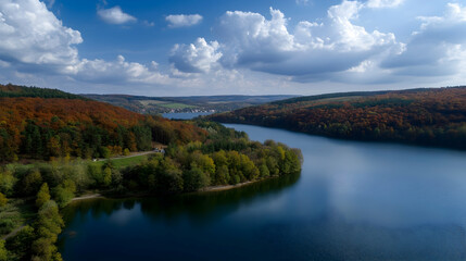 Naklejka premium Autumnal lake landscape, aerial view, colorful foliage, calm water, scenic background, ideal for travel brochures