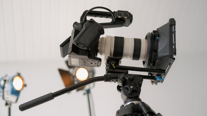 Camera tripod. Video studio. Professional filming equipment indoor with spotlights. Modern shooting photographer digital tool closeup.
