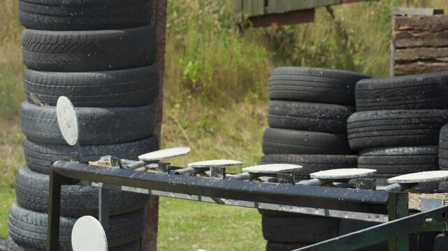 Static shot of targets being hit with bullets at gun range in the day