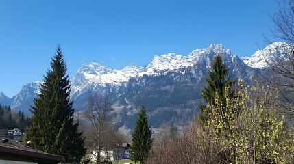 Obraz premium Snowy mountain range viewed from village, sunny spring day, travel postcard