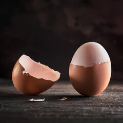 A cracked egg sits on a wooden table