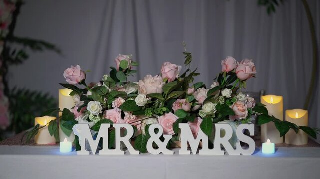 The charming Mr Mrs sign, beautifully surrounded by exquisite pink and white roses, creates an enchanting display that is perfect for any romantic wedding setting and truly captivates the heart