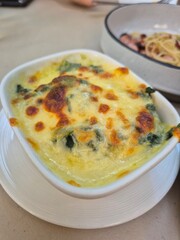 Traditional baked spinach with cream sauce and topping with cheese. Famous Italian food menu in restaurant.