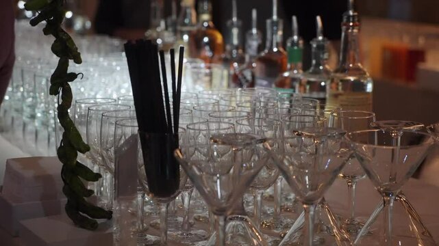 A beautifully pristine martini glass prominently stands out in the midst of an elegant row of exquisite glassware