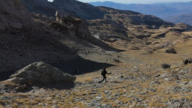 Dramatic drone shot of a hiker in the mountains