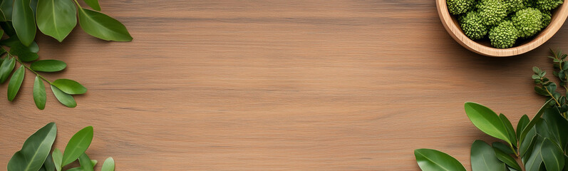 Fototapeta premium Wooden Tabletop with Greenery: A rustic brown wooden tabletop provides a natural, minimalist backdrop, adorned with vibrant green leaves arranged symmetrically along the edges.