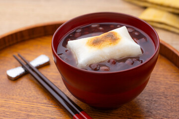 木目のテーブルに香ばしく焼かれたお餅入りのぜんざい