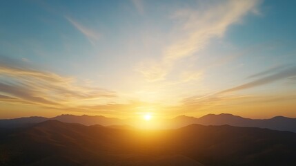 Obraz premium Serene Sunrise Over Mountain Ranges with Golden Glow Illuminating the Horizon and Soft Clouds in a Tranquil Sky – Ideal Scenic Nature Photography for Inspiration and Relaxation