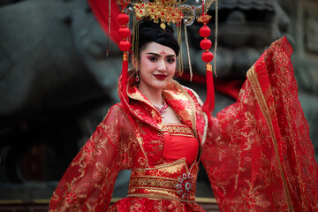 portrait of young asian woman wearing a traditional Chinese red dress is posing.