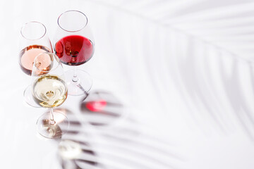 Three wine glasses filled with red, white, and rose wine