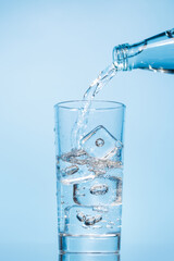 Crystal clear water being poured into a transparent glass, creating refreshing ripples and bubbles