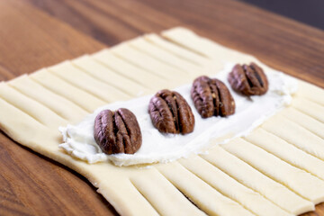 The process of making puff pastry with cream cheese and pecans. Baking concept. Homemade food. Baking cakes in the oven.
