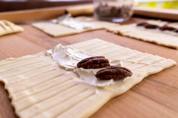 The process of making puff pastry with cream cheese and pecans. Baking concept. Homemade food. Baking cakes in the oven.