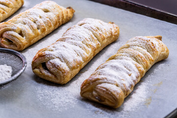 Delicious homemade cakes. Puff pastry with cherries, generously sprinkled with icing sugar on top. Delicious fresh buns close up view