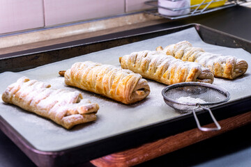 Delicious homemade cakes. Puff pastry with cherries, generously sprinkled with icing sugar on top. Delicious fresh buns close up view