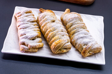 Delicious homemade cakes. Puff pastry with cherries, generously sprinkled with icing sugar on top. Delicious fresh buns close up view