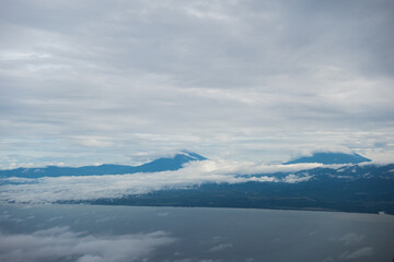 Beautiful mountains, coastline and white clouds seen from the airplane window