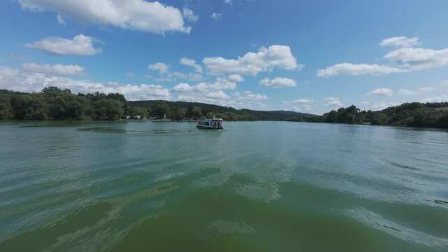 Tourist scenic river boat cruise on wide expanse of water Vltava Czech republic