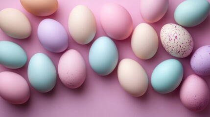 Brightly colored pastel eggs arranged creatively on a soft pink background for an artistic spring celebration