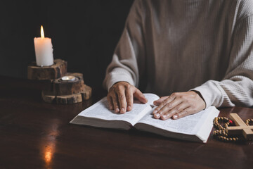 Hand of woman while praying for christian religion, Casual woman praying with her hands together over a  Bible with faith.