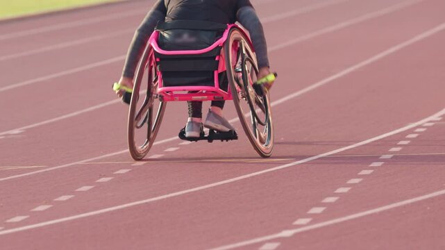 A man in a wheelchair is racing on a track. Concept of determination and perseverance, as the man is pushing himself to the limit despite his physical limitations