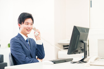 オフィスの電話で話すビジネスマン