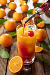 Classic tequila sunrise cocktail on an old wooden table.