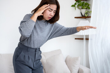 Asian woman experiencing dizziness and lightheadedness upon standing due to postural hypotension