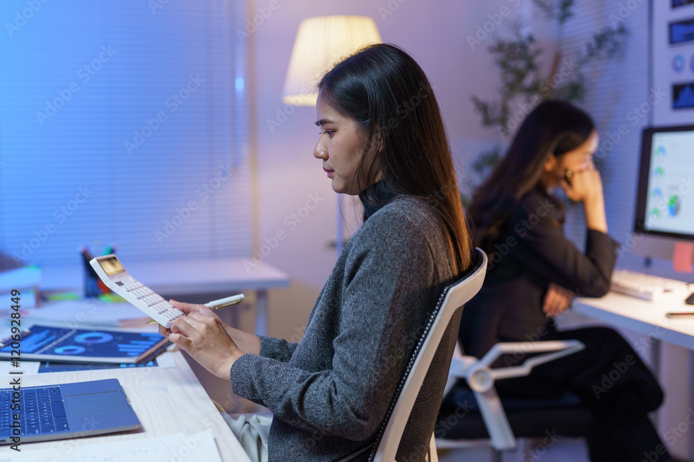 Poster focused employee calculating financial indicators while using a calculator and reviewing documents, 
