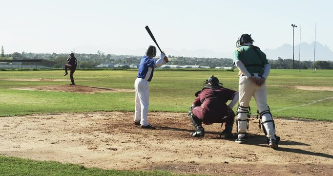 Multiracial male baseball players and umpire playing baseball on a pitch, slow motion