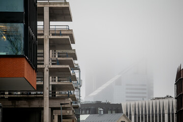 Fototapeta premium new construction building project with new architecture skyscraper buildings in mist in the background. Building industry slowing down in down construction time