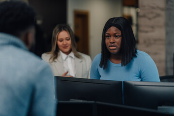 Business team working together on project using desktop computers in office