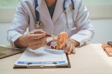 Male doctor treating ear diseases at a hospital, discussing conditions like deafness,tinnitus,...