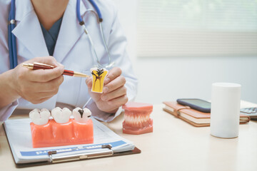 Male doctor treating dental diseases at a hospital, discussing tooth decay, crooked teeth broken...